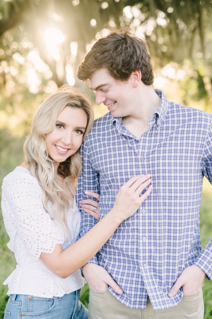 Darling engagement portrait featuring a woman with her hand on her fiance's chest and looking forward by Christina Elliott Photography at Brazos Bend State Park. engagement portraits stunning summer light couple pic #christinaelliottphotography #christinaelliottengagements #houstonengagements #brazosbendstateparkengagements #brazosbendphotography #houstonengagementphotographer #weddingannoucementphotos #houstonphotographers #couplegoals #soontobemarried #engaged #engagementphotos