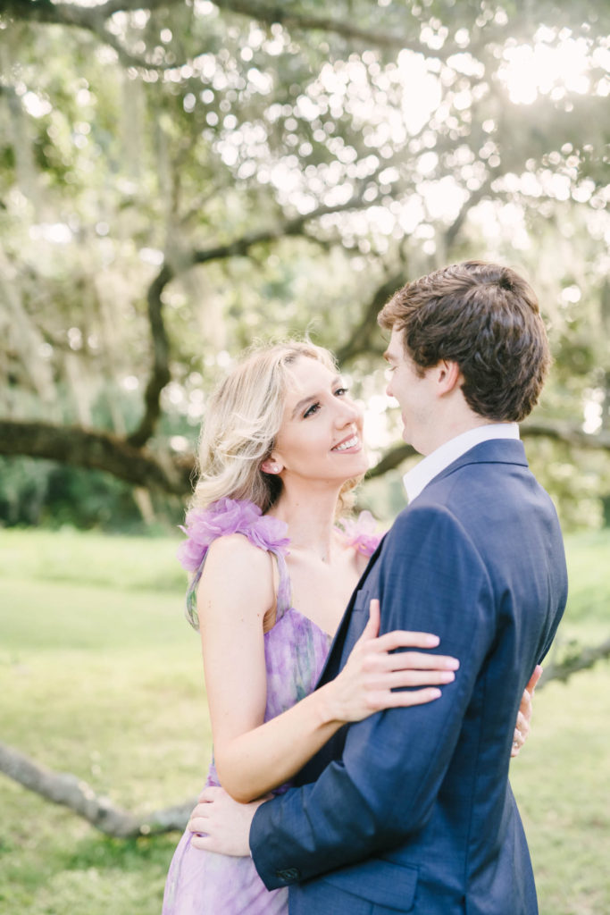 During a Houston engagement session, Christina Elliott Photography captures a newly engaged couple smiling and gazing into each other's eyes all dressed up in a suit and fancy dress. semi-formal engagement style engagement poses #christinaelliottphotography #christinaelliottengagements #houstonengagements #brazosbendstateparkengagements #brazosbendphotography #houstonengagementphotographer #weddingannoucementphotos #houstonphotographers #couplegoals #soontobemarried #engaged #engagementphotos