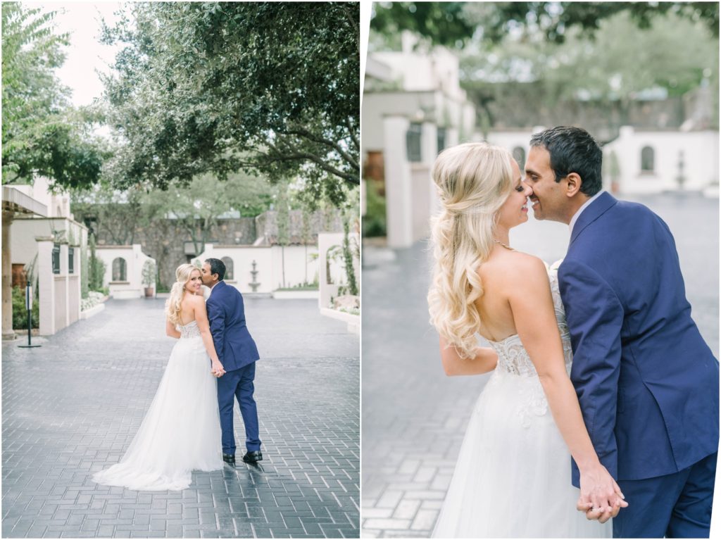In the courtyard at The Bell Tower on 34th in Houston Christina Elliott Photography captures a bride and groom kissing under green trees. bride and groom goals outdoor bridal photos blue suit #christinaelliottphotography #christinaelliottweddings #thebelltoweron34th #belltowerwedding #houstonweddings #houstonweddingphotographers #mrandmrs #newlymarried #weddinginspiration #bridalgown #groomstyle #texasweddingphotographers #tietheknot #traditionalindianwedding