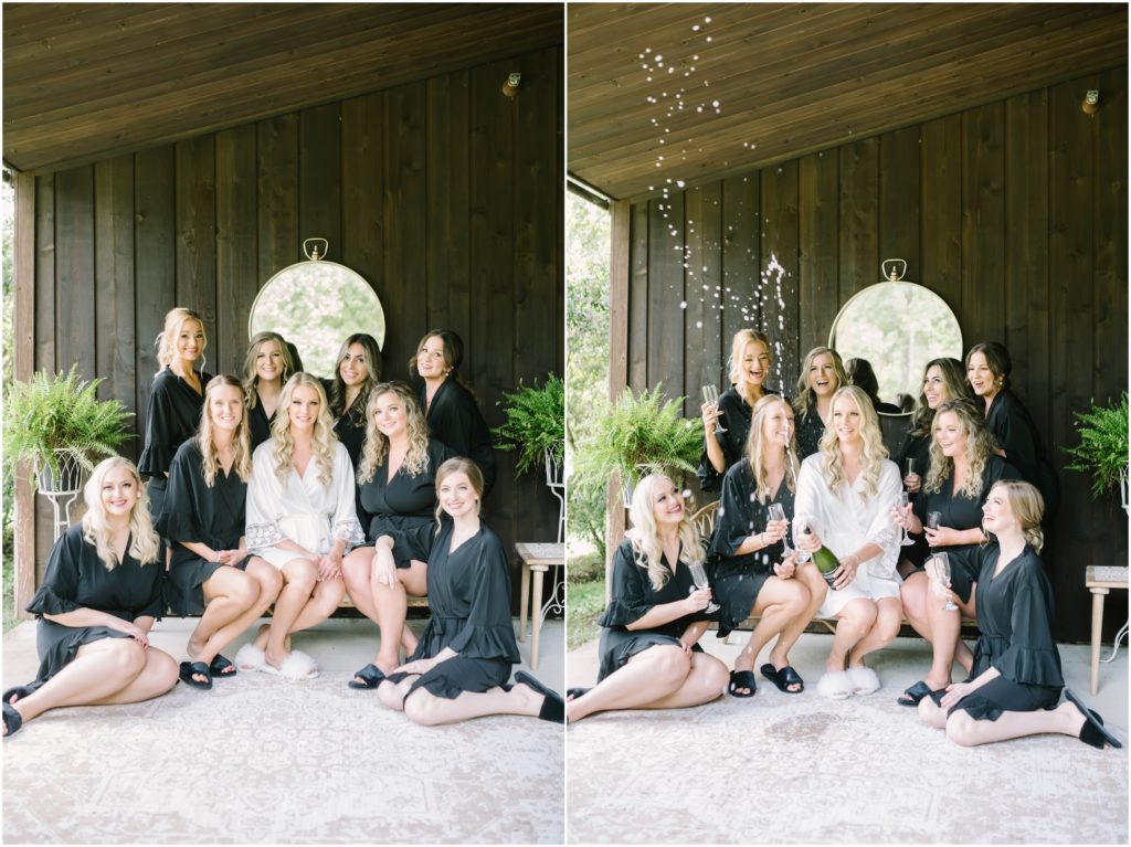 Bridal Party wearing white and black robes sit in chairs and open the champagne to celebrate at the Carriage House in Houston by Christina Elliott Photography. champagne toast bridesmaids matching robes #christinaelliottphotography #christinaelliottweddings #houstontx #houstonweddings #houstonweddingphotographers #carriagehousewedding #conroetexas #texasweddingvenues #carriagehousechapel #cottageweddings #farmhousewedding #sweatheartweddinggown #countrywedding #weddinginspiration