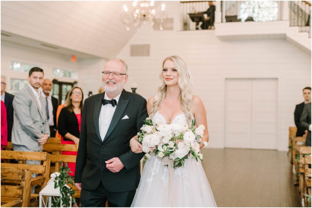 Father of the bride walks his daughter down the aisle in a white chapel in Conroe, Texas by Christina Elliott Photography. father of the bride father's joy wedding walk here comes the bride #christinaelliottphotography #christinaelliottweddings #houstontx #houstonweddings #houstonweddingphotographers #carriagehousewedding #conroetexas #texasweddingvenues #carriagehousechapel #cottageweddings #farmhousewedding #sweatheartweddinggown #countrywedding #weddinginspiration