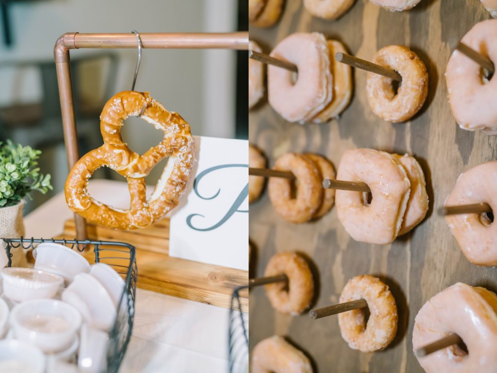 At a Still Waters Ranch wedding, a couple serves donuts on a donut board and fresh pretzels by Christina Elliott Photography. fun wedding food donuts and pretzels #christinaelliottphotography #texasweddingphotographer #ranchwedding #countrychic