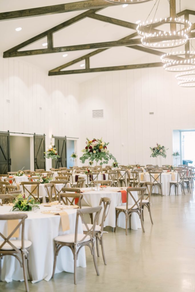 Reception room setup with white table cloths and rustic wood chairs in Texas with Christina Elliott Photography. rustic country wedding reception ideas #christinaelliottphotography #texasweddingphotographer #ranchwedding #countrychic