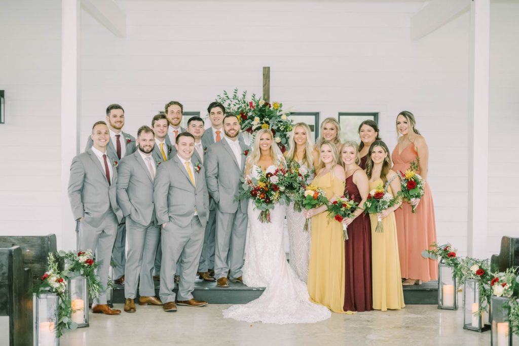 Wedding with yellow, oranges, and reds for the colors with an indoor wedding altar by Christina Elliott Photography. fall wedding colors indoor marriage #christinaelliottphotography #texasweddingphotographer #ranchwedding #countrychic