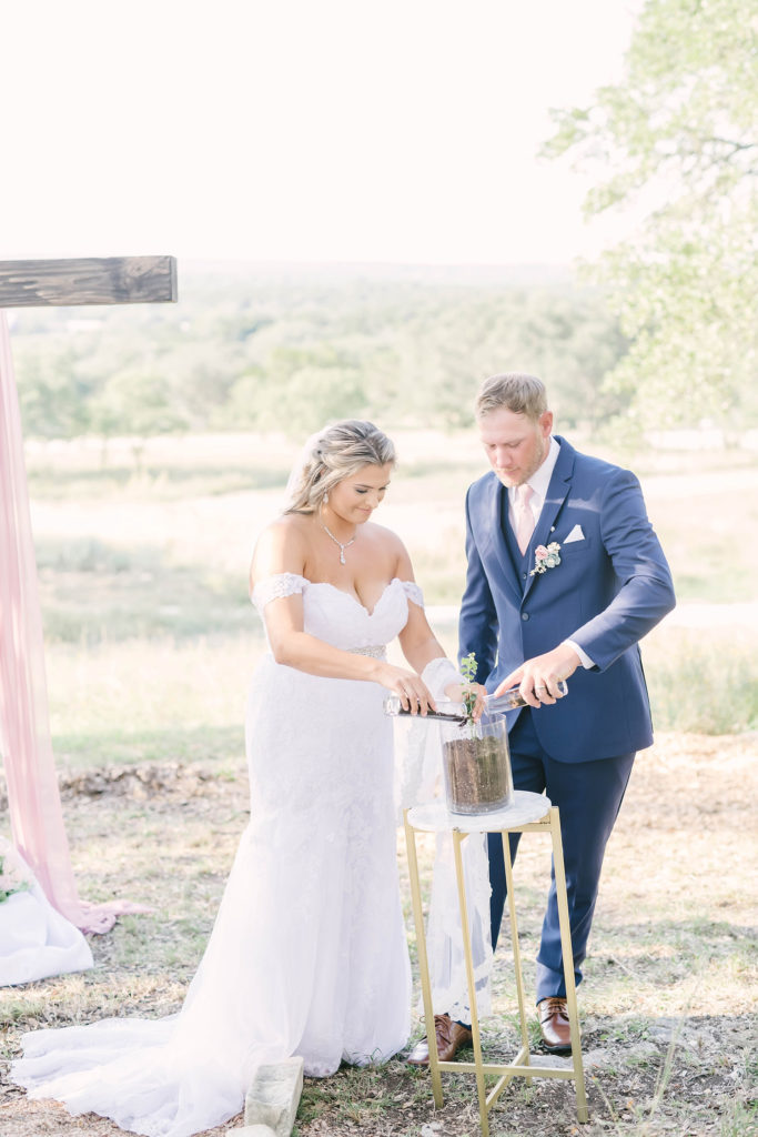 Bride and groom pour dirt into their unity plant to grow