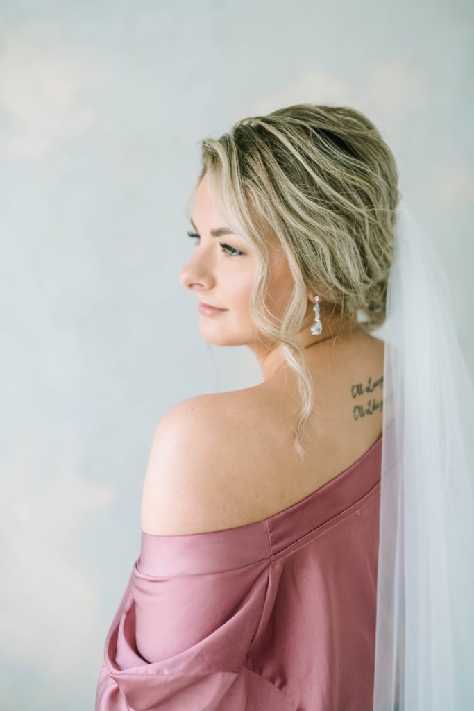 Bride with an updo and tattoo on her back gets ready for her wedding day by Christina Elliott Photography. bridal getting ready pictures #christinaelliottphotography #theoakatelierwedding #Houstonwinterweddings #weddingphotographersHouston