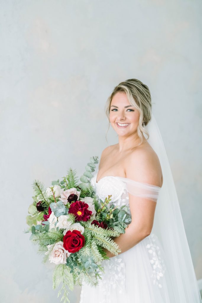 Beautiful portrait of a bride holding a winter rose bouquet by Christina Elliott Photography. texas photographer winter rose bouquet #christinaelliottphotography #theoakatelierwedding #Houstonwinterweddings #weddingphotographersHouston