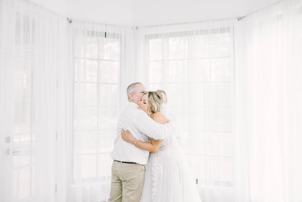 The father of the bride hugs his daughter during the first look at Oak Atelier by Christina Elliott Photography. father and bride Oak Atelier #christinaelliottphotography #theoakatelierwedding #Houstonwinterweddings #weddingphotographersHouston