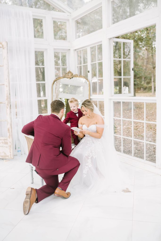 Groom kneels and the bride sits as they share intimate vows captured by Christina Elliott Photography. intimate vow reading groom kneels #christinaelliottphotography #theoakatelierwedding #Houstonwinterweddings #weddingphotographersHouston