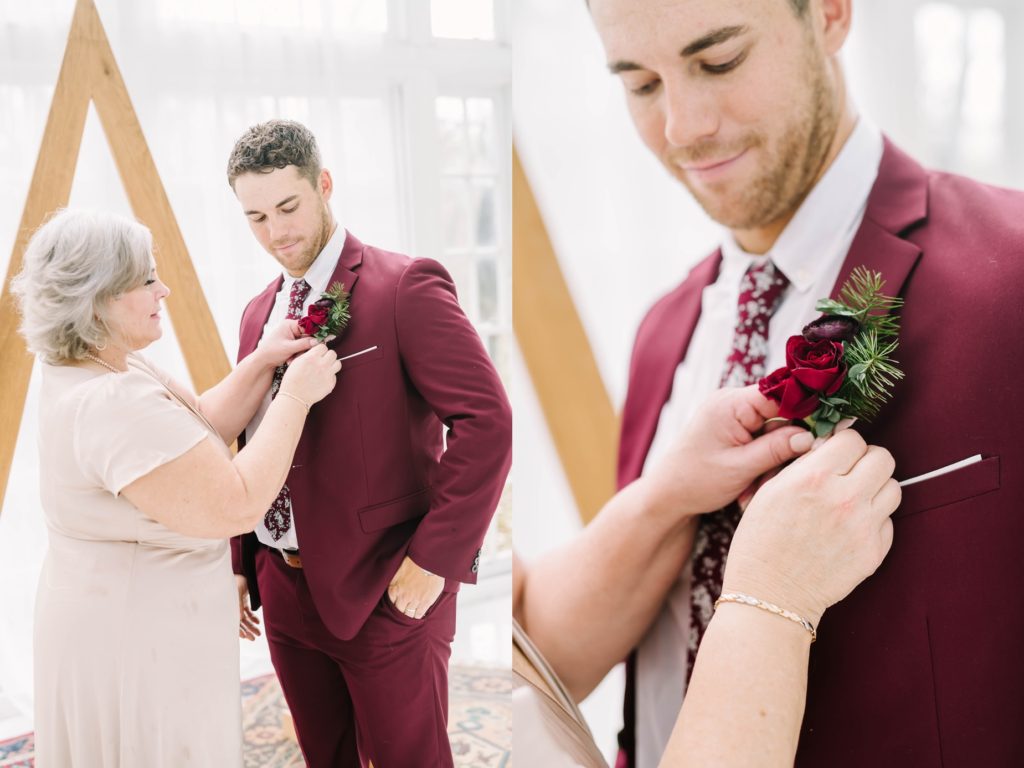 The mother of the groom pins on the groom's boutonniere for the TX wedding by Christina Elliott Photography. groom boutonniere pinning #christinaelliottphotography #theoakatelierwedding #Houstonwinterweddings #weddingphotographersHouston