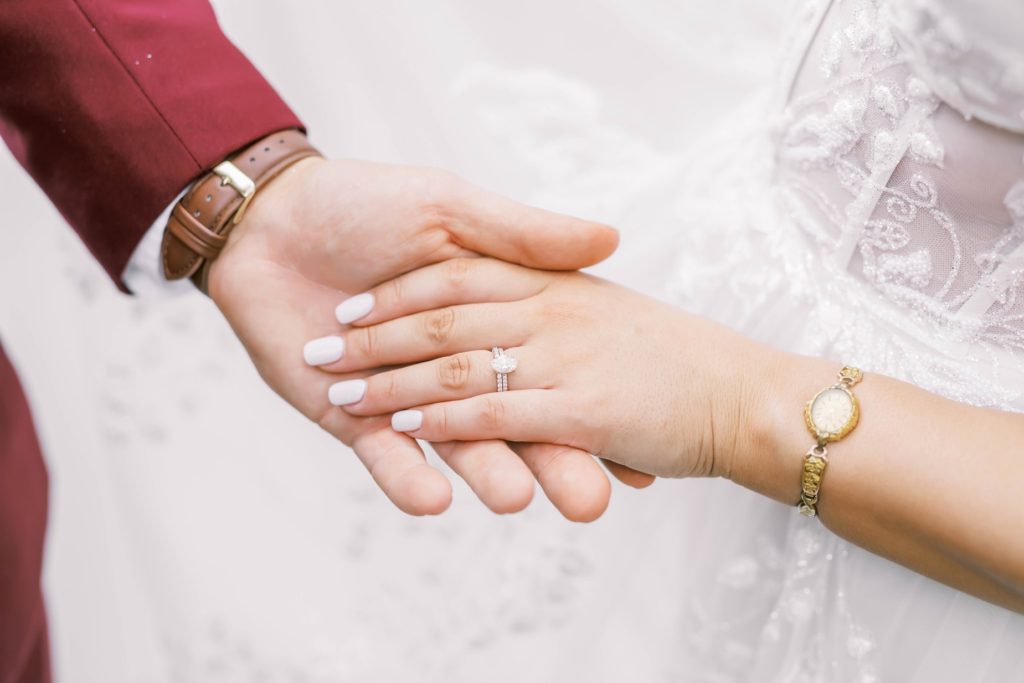 Bride and groom detailed photo of the ring and bracelet by Christina Elliott Photography. ring on the hand holding hands bride and groom #christinaelliottphotography #theoakatelierwedding #Houstonwinterweddings #weddingphotographersHouston