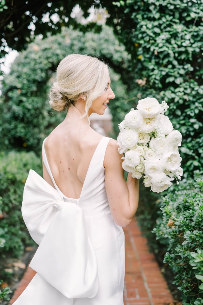 Detailed shot of a traditional minimalist wedding style bridal gown and hairstyle by Christina Elliott Photography. minimalist wedding style #christinaelliottphotography #houstonweddings #riveroaksgardenclub #outdoorbridals #houstonbridals
