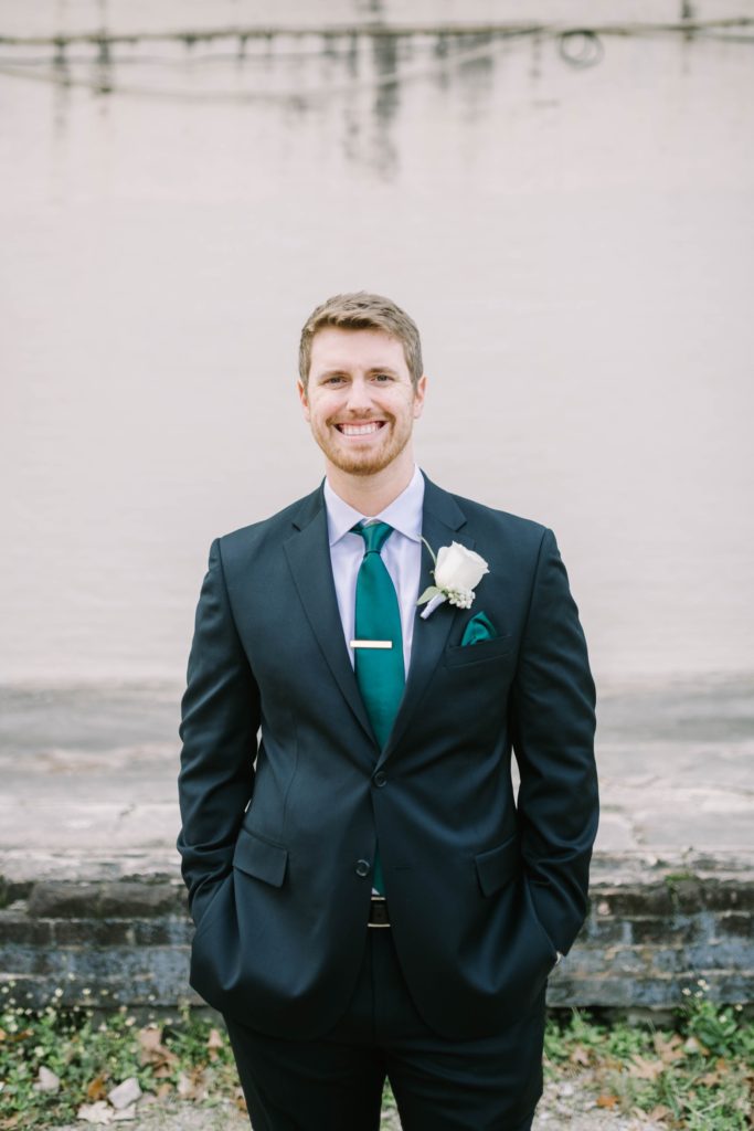 Houston wedding photographer captures a groom portrait in front of a brick wall by Christina Elliott Photography. traditional wedding style groom fashion #christinaelliottphotography #thesamhoustonhotel #houstonweddings #TXweddingphotographer