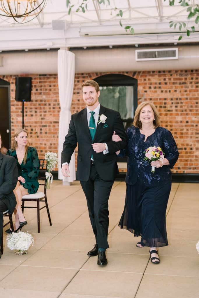 Mother of the groom walks her son down the aisle at the Sam Houston Hotel in Texas by Christina Elliott Photography. bride and mother groom down the aisle #christinaelliottphotography #thesamhoustonhotel #houstonweddings #TXweddingphotographer