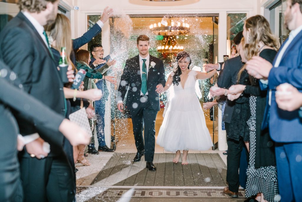 A newly married couple leaves the wedding in a sea of sparkles captured by Christina Elliott Photography, a wedding photographer in TX. wed send-off #christinaelliottphotography #thesamhoustonhotel #houstonweddings #TXweddingphotographer