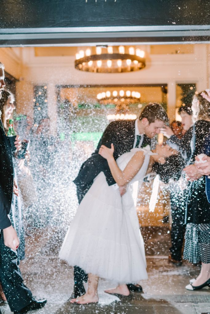 Christina Elliott Photography captures a groom dipping a bride during a sparkling send-off in Houston. fun wedding send-offs sparkle departures shoeless bride #christinaelliottphotography #thesamhoustonhotel #houstonweddings #TXweddingphotographer