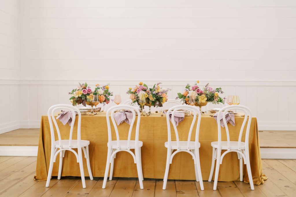 Mustard Luncheon table with spring florals and white country chairs by Christina Elliott Photography in Texas. spring wedding luncheon #christinaelliottphotography #Houstonweddings #arrowheadhill #weddingphotographersHouston #springwedding #sayIdo