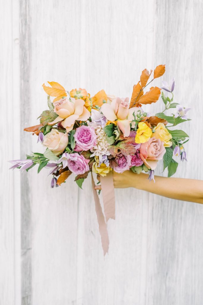 A springtime-inspired bouquet with pinks, purples, oranges, and yellow was captured by Christina Elliott Photography. colorful bouquet #christinaelliottphotography #Houstonweddings #arrowheadhill #weddingphotographersHouston #springwedding #sayIdo