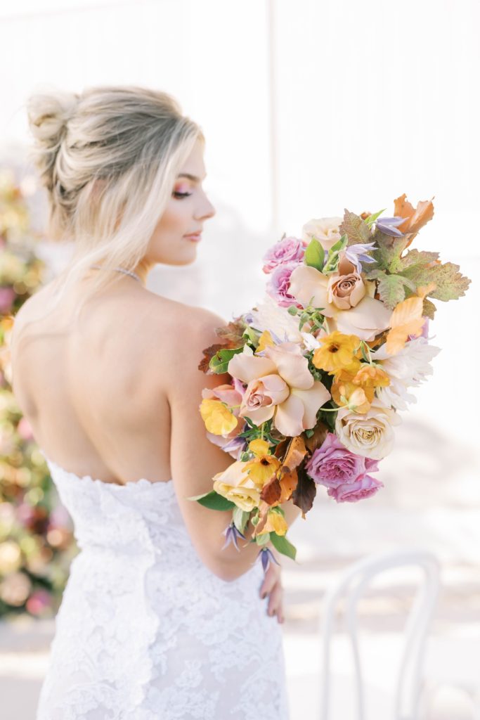 Bride wearing a lace strapless gown and holding a colorful bouquet by Christina Elliott Photography. lace gown colorful bridal bouquet #christinaelliottphotography #Houstonweddings #arrowheadhill #weddingphotographersHouston #springwedding #sayIdo