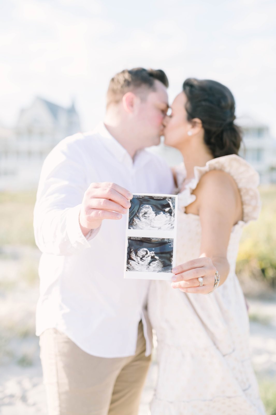 Couple kisses while holding an ultrasound picture by Christina Elliott Photography in the Galveston area. Galveston photographers ultrasound #ChristinaElliottPhotography #ChristinaElliottMaternity #Galvestonmaternityphotographers #maternityportraits