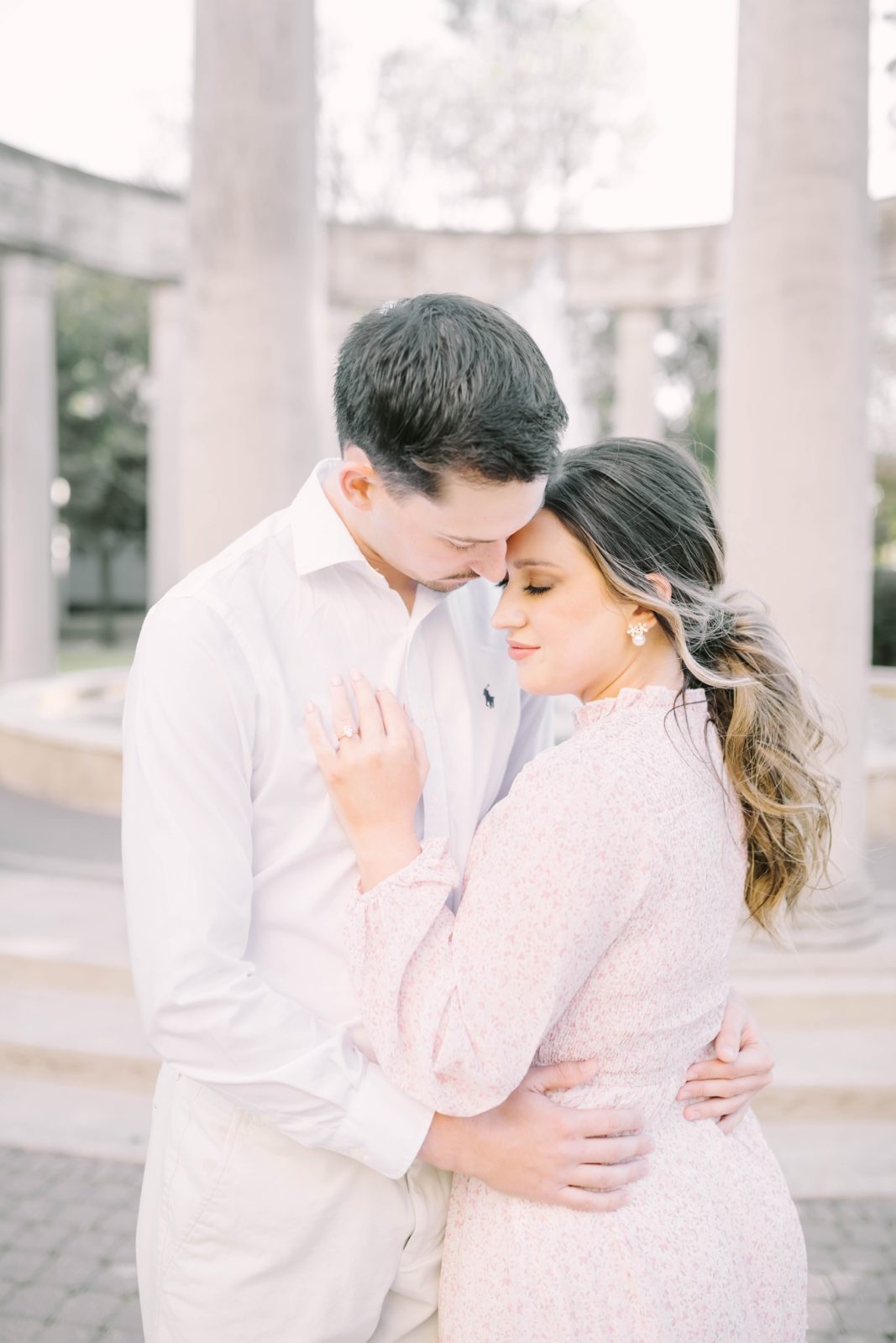 A woman wearing pearls snuggles into her fiance by Christina Elliott Photography. eyes closed snuggling portrait #christinaelliottphotography #Houstonengagements #riceuniversity #springengagements #sayIdo #Houstonengagementphotographers