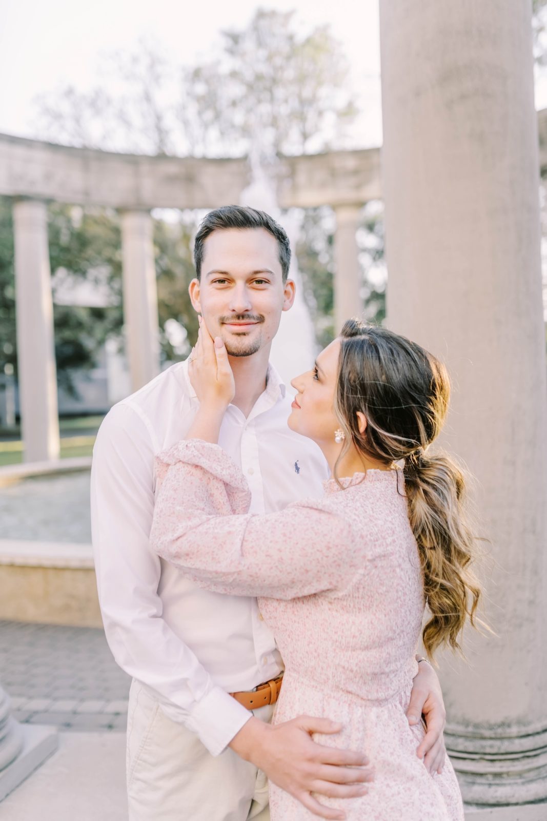 A man looks ahead as a woman holds his cheek tenderly by Christina Elliott Photography. Rice University photography location #christinaelliottphotography #Houstonengagements #riceuniversity #springengagements #sayIdo #Houstonengagementphotographer