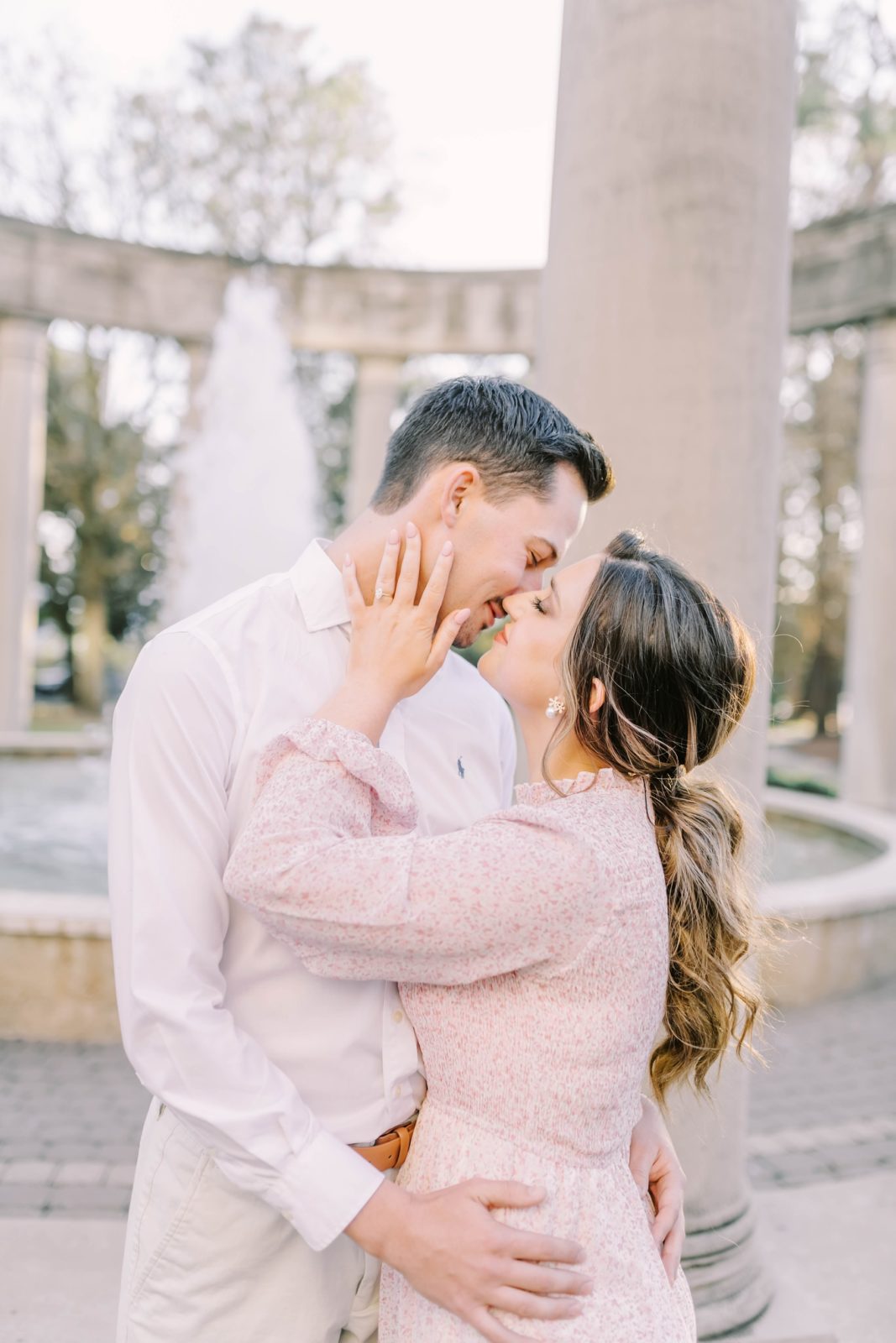 Engaged couple kisses in front of a fountain at Rice University by Christina Elliott Photography. engaged she said yes #christinaelliottphotography #Houstonengagements #riceuniversity #springengagements #sayIdo #Houstonengagementphotographers
