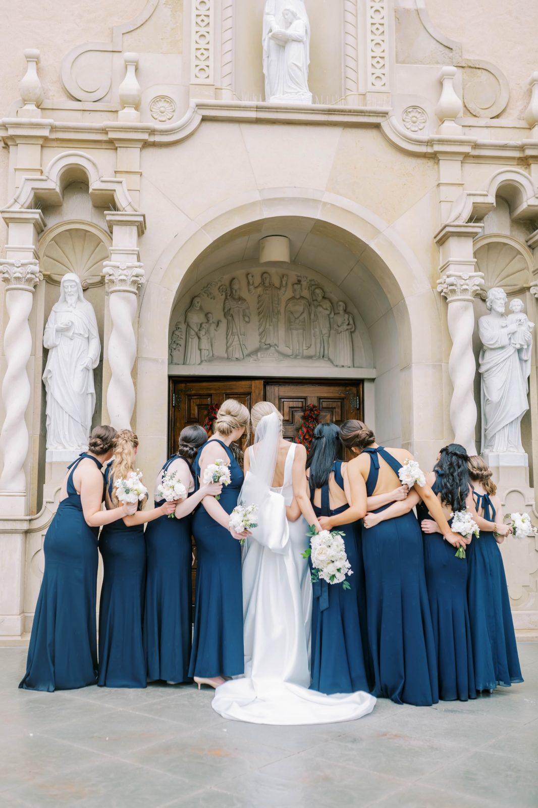 A bridal party in front of Houston's St. Anne Catholic church by Christina Elliott Photography. church wedding catholic wedding #christinaelliottphotography #Houstonweddings #catholicchurchweddings #navyblue #sayIdo #Houstonweddingphotographers