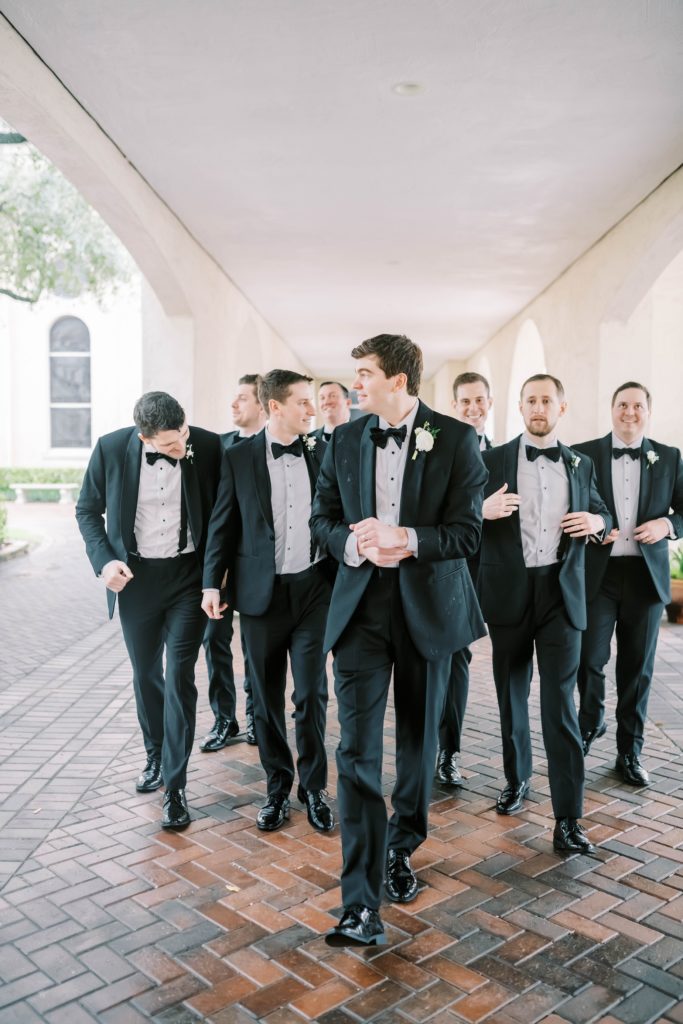 Houston photographer Christina Elliott Photography captures groomsmen and his pose all in black. black bowtie for wedding #christinaelliottphotography #Houstonweddings #catholicchurchweddings #navyblue #sayIdo #Houstonweddingphotographers