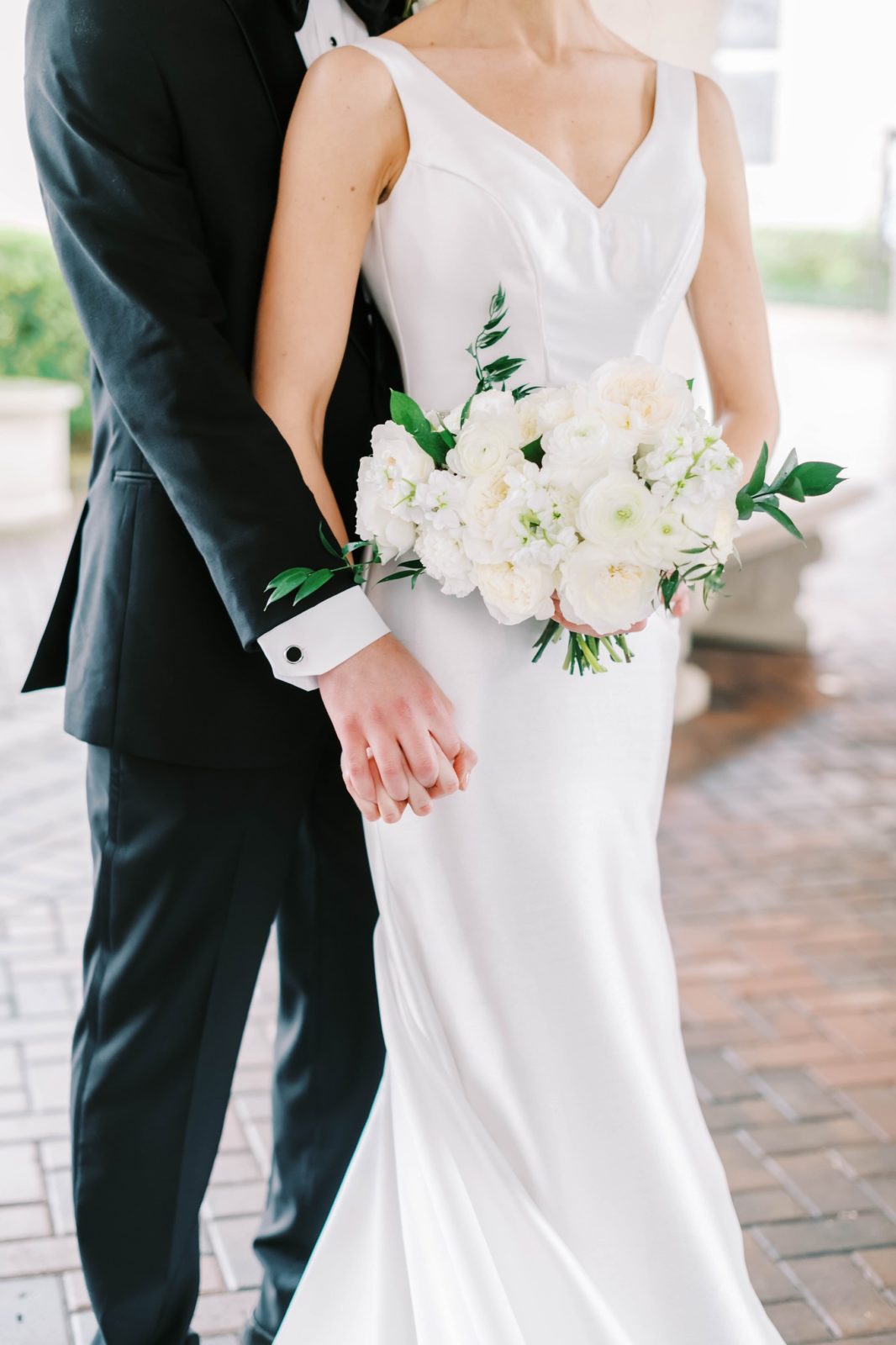 Christina Elliott Photography captures a close-up of a bridal gown and bridal bouquet in Houston, Texas. Houston wedding photographer #christinaelliottphotography #Houstonweddings #catholicchurchweddings #navyblue #sayIdo #Houstonweddingphotographers