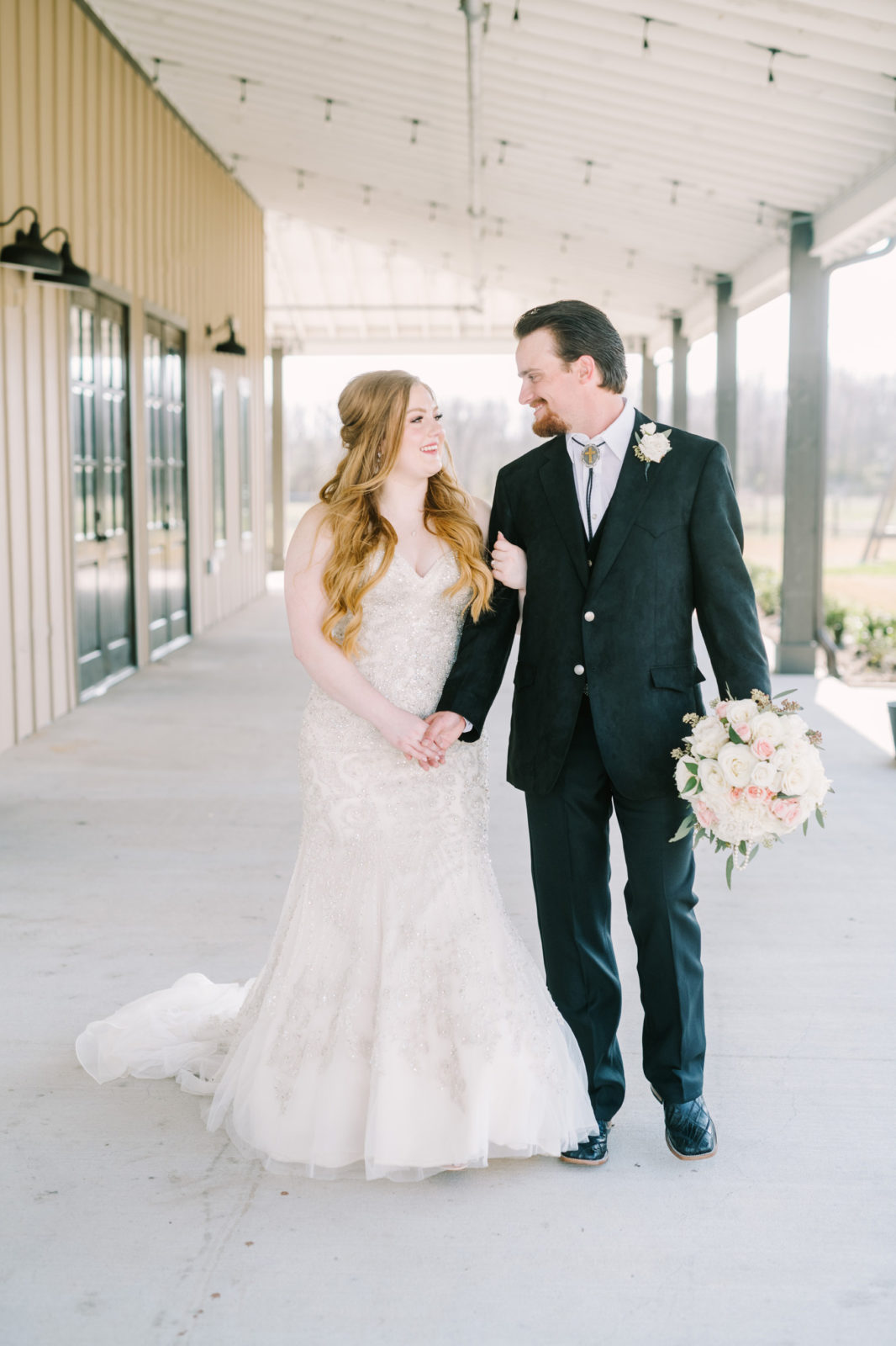 Newlyweds walk holding hands on their wedding day in Texas by Christina Elliott Photography. southern wedding vibe #ChristinaElliottPhotography #ChristinaElliottWeddings #StillWatersRanchWedding #Texasweddings #countrywedding #ranchwedding