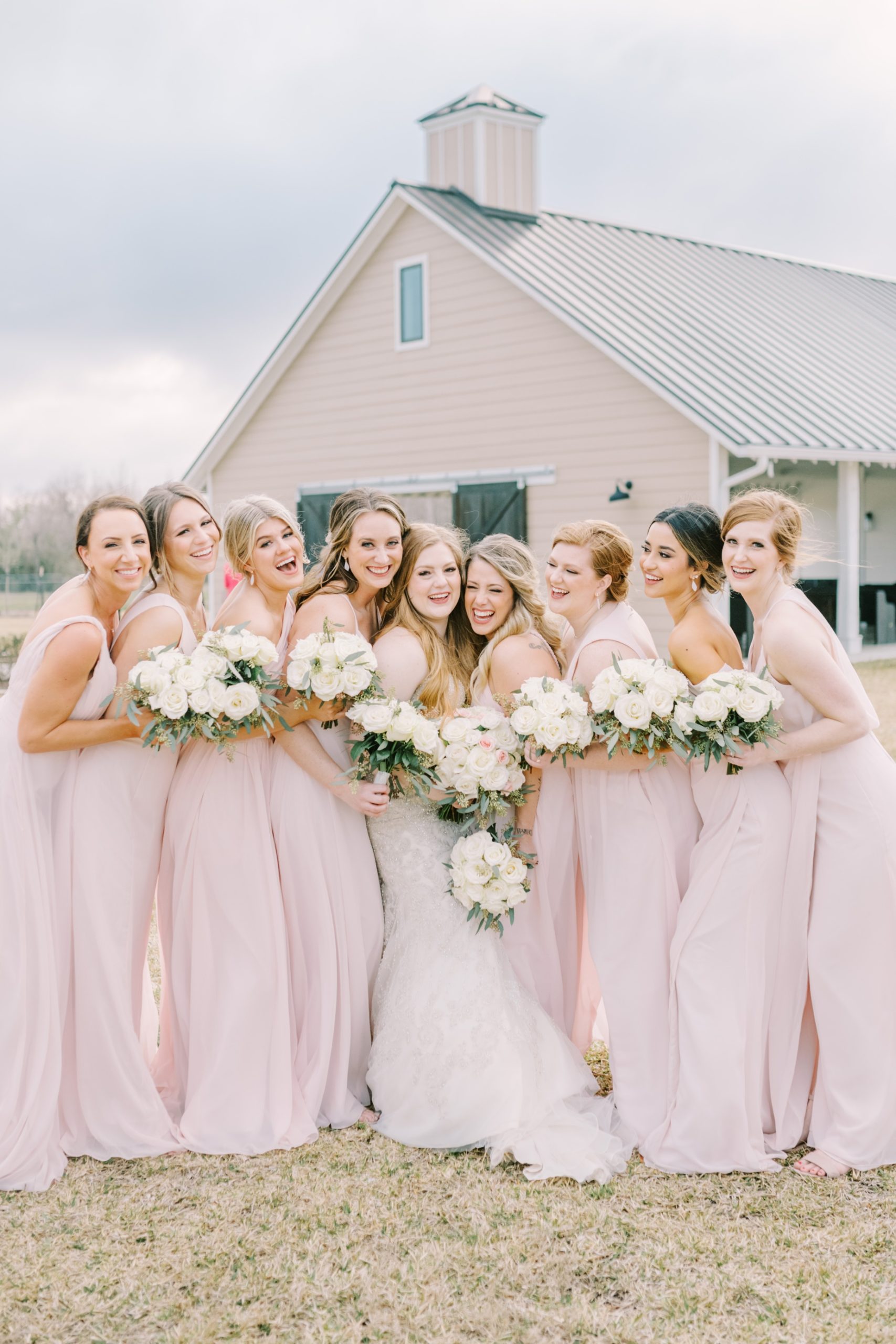 A bride laughs with her group of bridesmaids all squished together by Christina Elliott Photography. squished bridesmaid laugh #ChristinaElliottPhotography #ChristinaElliottWeddings #StillWatersRanchWedding #Texaswedding #countrywedding #ranchwedding