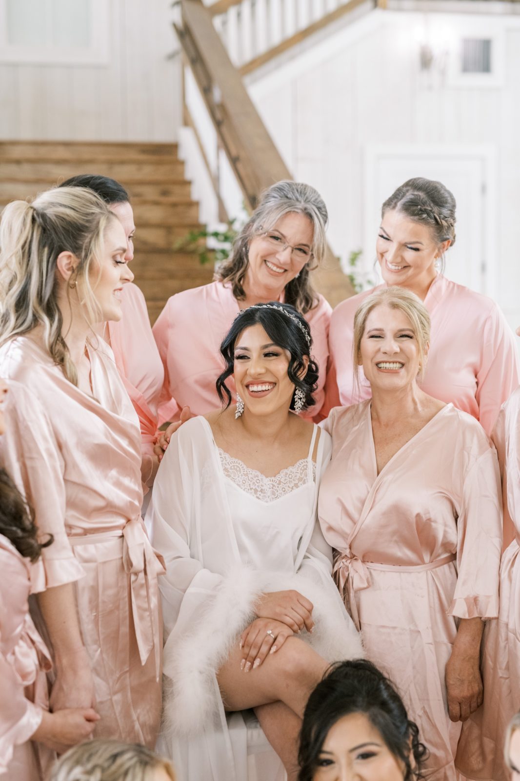 Bride with the bridal party all wearing pink robes on the stairs by Christina Elliott Photography. pink bridesmaids robes #ChristinaElliottPhotography #ChristinaElliottWeddings #Houstonweddings #TheSpringsVenue #EastHoustonweddings #Mrs #Mr