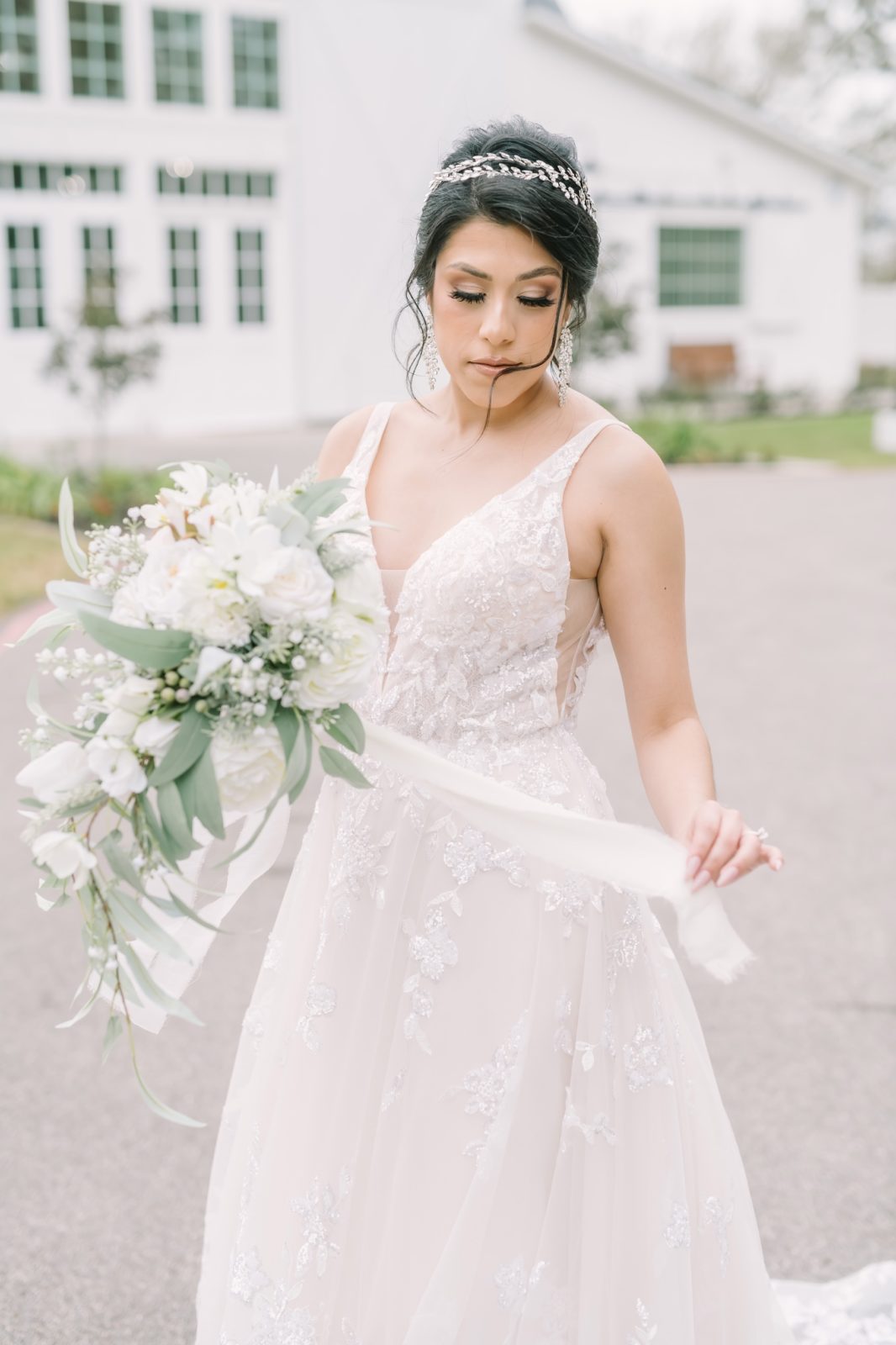 Bride in a lace v-neck wedding gown and white floral bouquet by Christina Elliott Photography. farmhouse bridal updo #ChristinaElliottPhotography #ChristinaElliottBridals #Houstonweddings #Farmhousewedding #TheSpringsVenue #BridalsHouston