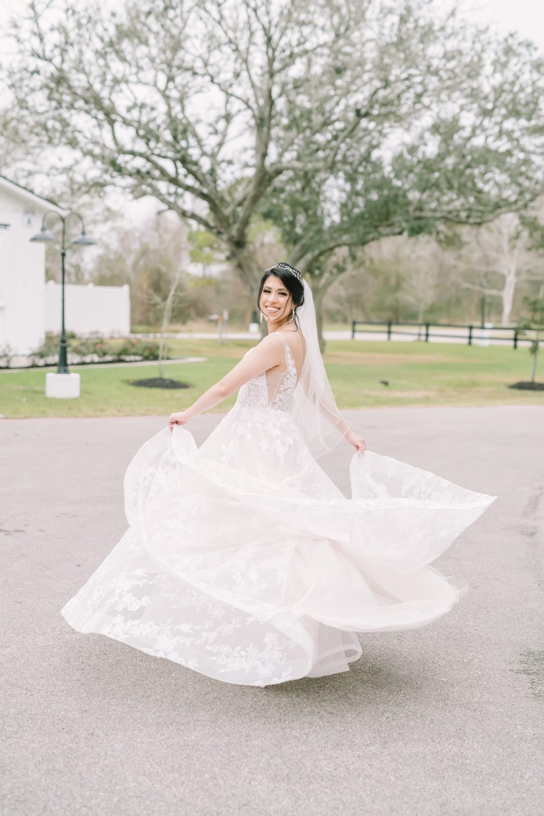 A bride twirls around in her dress in front of a farmhouse by Christina Elliott Photography. dancing bride dress twirl #ChristinaElliottPhotography #ChristinaElliottBridals #Houstonweddings #Farmhousewedding #TheSpringsVenue #BridalsHouston