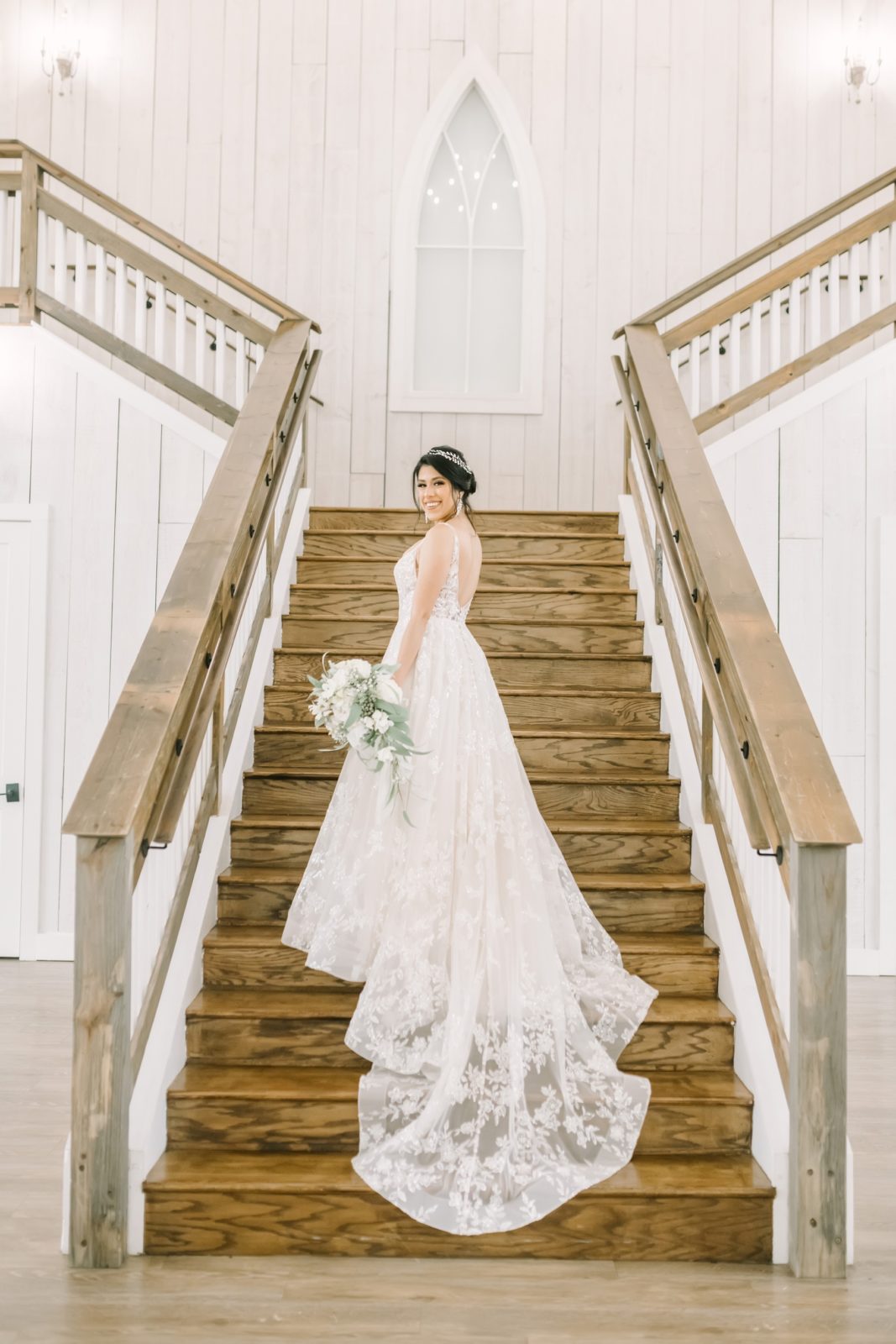 Christina Elliott Photography captures a bride standing on a wooden staircase in a farmhouse in Houston. bridal portraits #ChristinaElliottPhotography #ChristinaElliottBridals #Houstonweddings #Farmhousewedding #TheSpringsVenue #BridalsHouston