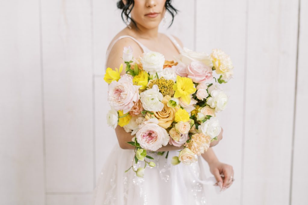 Detailed shot of a bridal bouquet featuring yellows, pinks, and whites by Christina Elliott Photography. spring bridal bouquets #ChristinaElliottPhotography #ChristinaElliottWeddings #Houstonwedding #TheSpringsVenue #EastHoustonweddings #Mrs #Mr