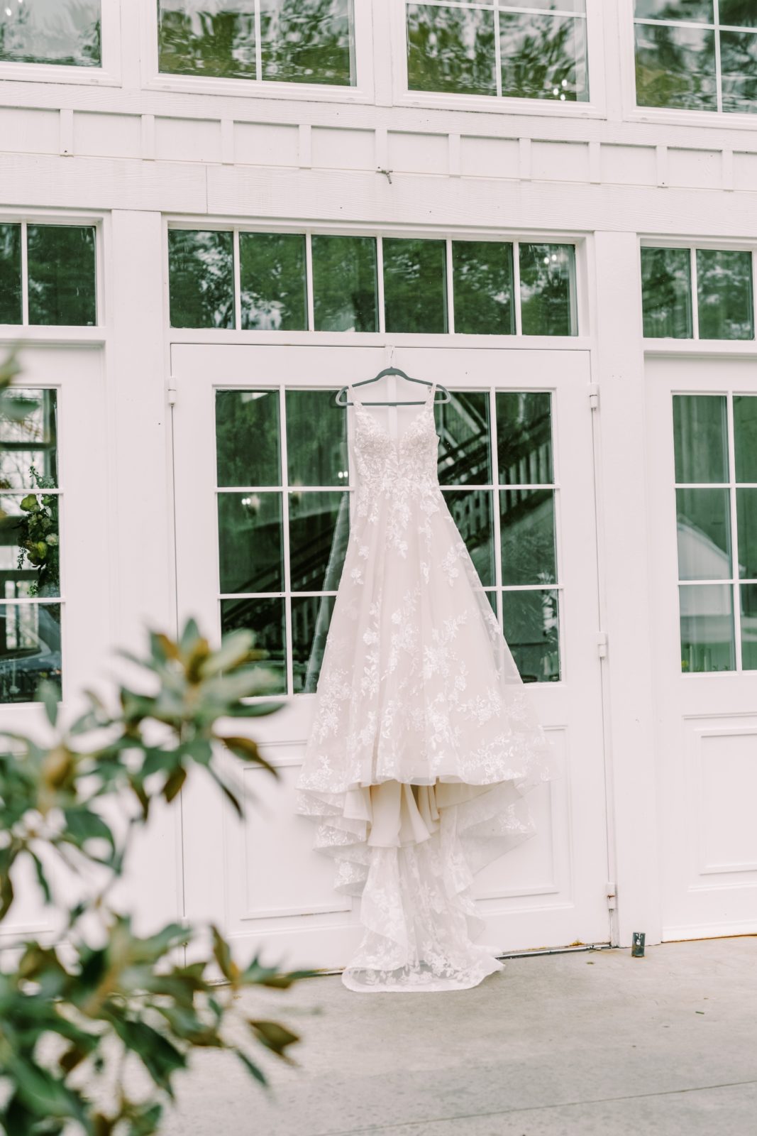 Lace wedding gown hanging up in a white window farmhouse in Houston by Christina Elliott Photography. lace wedding dress #ChristinaElliottPhotography #ChristinaElliottWeddings #Houstonweddings #TheSpringsVenue #farmhouse #EastHoustonweddings #Mrs #Mr