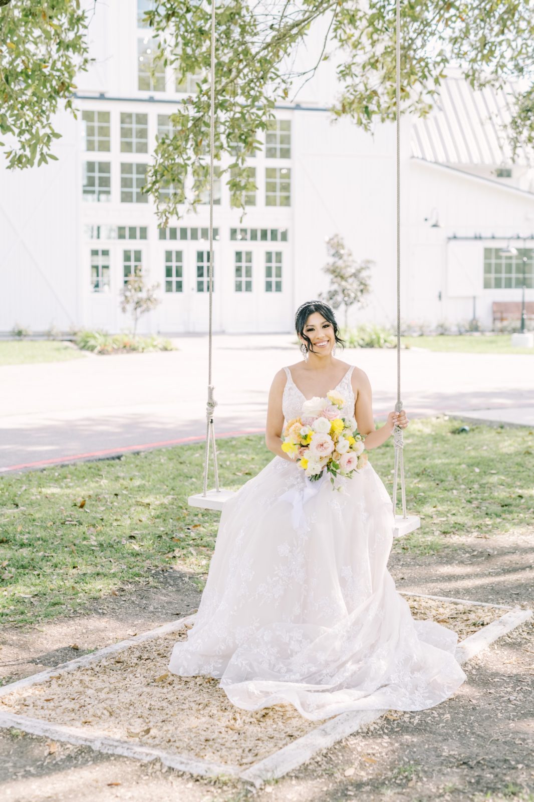 A bride wearing a lace halter wedding dress sits on a robe swing the country by Christina Elliott Photography. robe swing wedding #ChristinaElliottPhotography #ChristinaElliottWeddings #Houstonwedding #TheSpringsVenue #EastHoustonweddings #Mrs #Mr