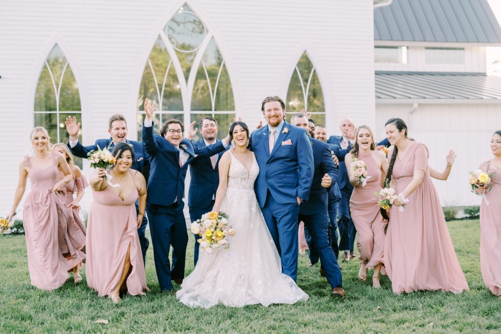 Newlywed couple and all their loved ones chatting on the barn grass by Christina Elliott Photography. newlyweds barn wedding ideas #ChristinaElliottPhotography #ChristinaElliottWeddings #Houstonwedding #TheSpringsVenue #EastHoustonweddings