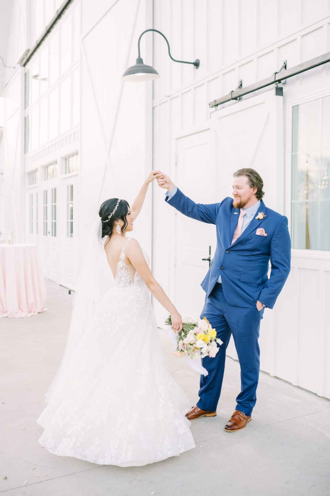 Christina Elliott Photography captures a newly married couple dancing outside a white barn. Texas weddings photographers in Houston #ChristinaElliottPhotography #ChristinaElliottWeddings #Houstonwedding #TheSpringsVenue #EastHoustonweddings