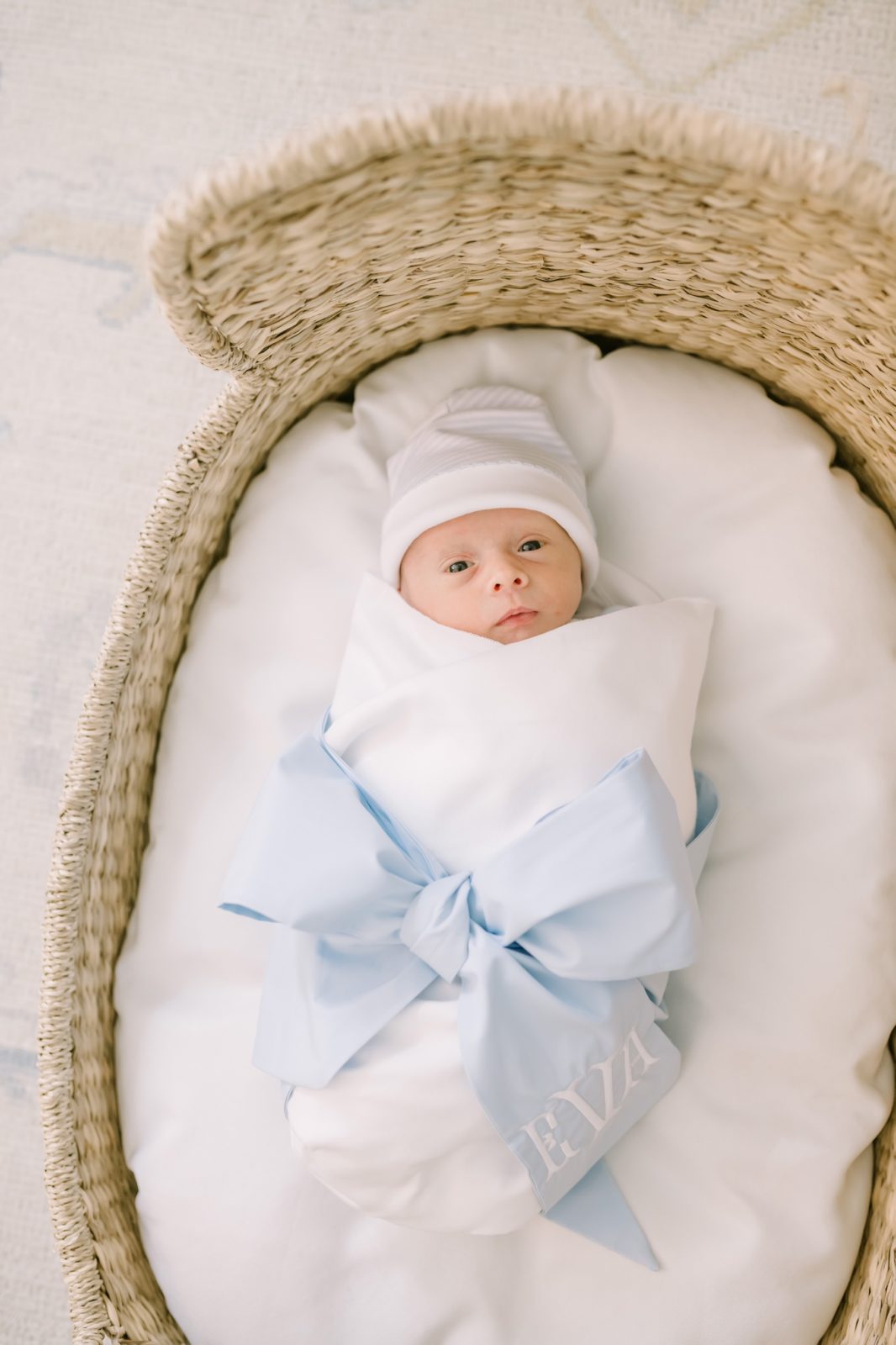 Newborn baby swaddled up with a bow wrapped around her captured by Christina Elliott Photography. bow around newborn baby girl #ChristinaElliottPhotography #ChristinaElliottNewborns #HoustonLifestyleNewborns #HoustonFamilyPhotographer