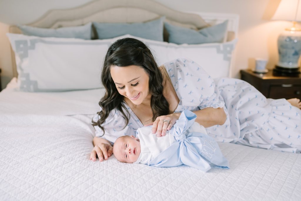 Baby girl laying on a bed with her mother looking down at her by Christina Elliott Photography. mothers love newborn baby #ChristinaElliottPhotography #ChristinaElliottNewborns #HoustonLifestyleNewborns #HoustonFamilyPhotographer