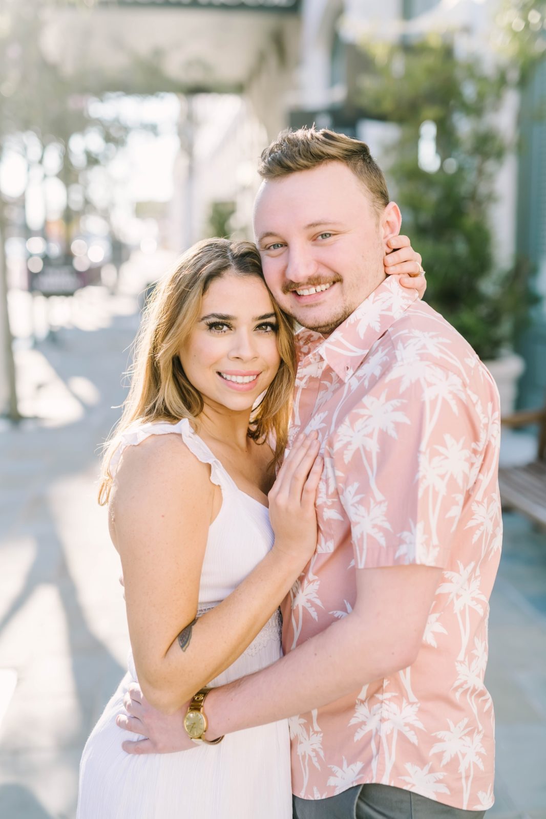 Summer engagement portraits with woman wearing white dress and man wearing pink button-up by Christina Elliott Photography. summer engagements #ChristinaElliottPhotography #ChristinaElliottEngagements #TheTremontHouse #Texasengagements #shesaidyes