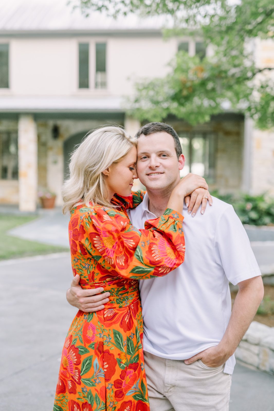 In a brightly colored dress, a woman snuggles into her husband-to-be by Christina Elliott Photography. fiesta dress inspiration #ChristinaElliottPhotography #ChristinaElliottEngagements #LakeLivingston #summerengagements #Texasphotographer