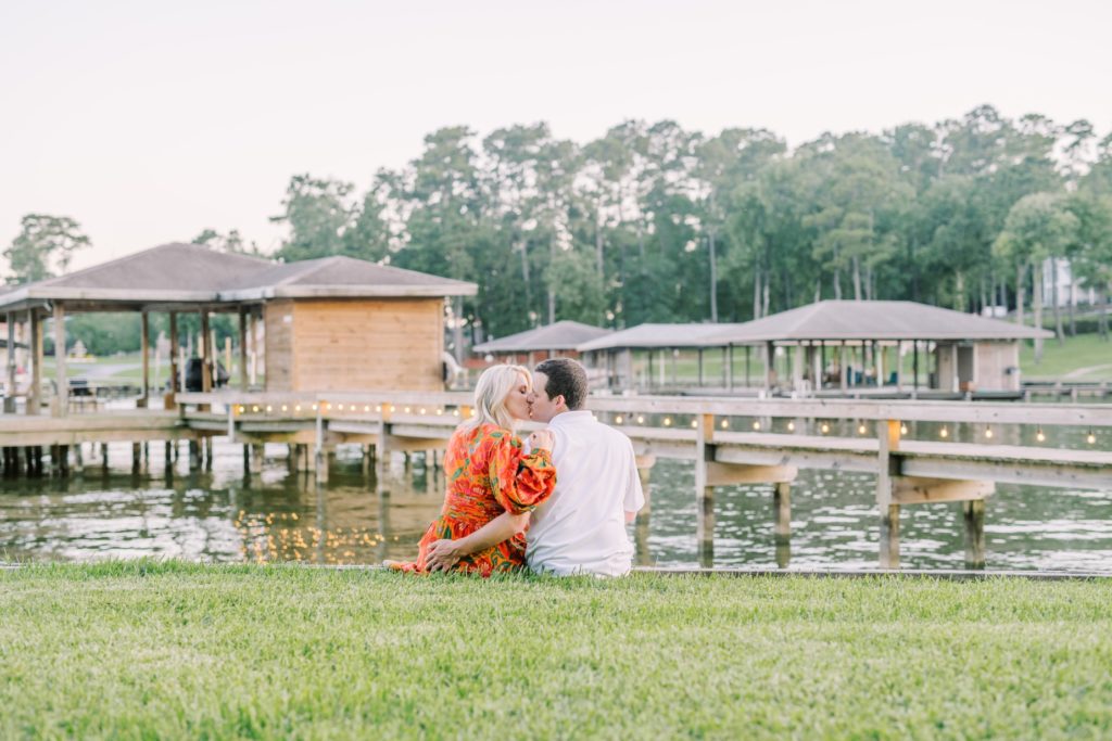 Christina Elliott Photography captures fiances kissing on a grass hill next to Livingston Lake. dreamy engagements Texas #ChristinaElliottPhotography #ChristinaElliottEngagements #LakeLivingston #summerengagements #Texasphotographer